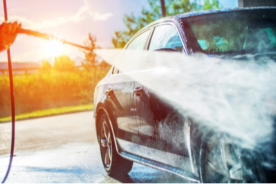 person cleaning a car outside