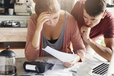 couple looking at expensive repair bills for car